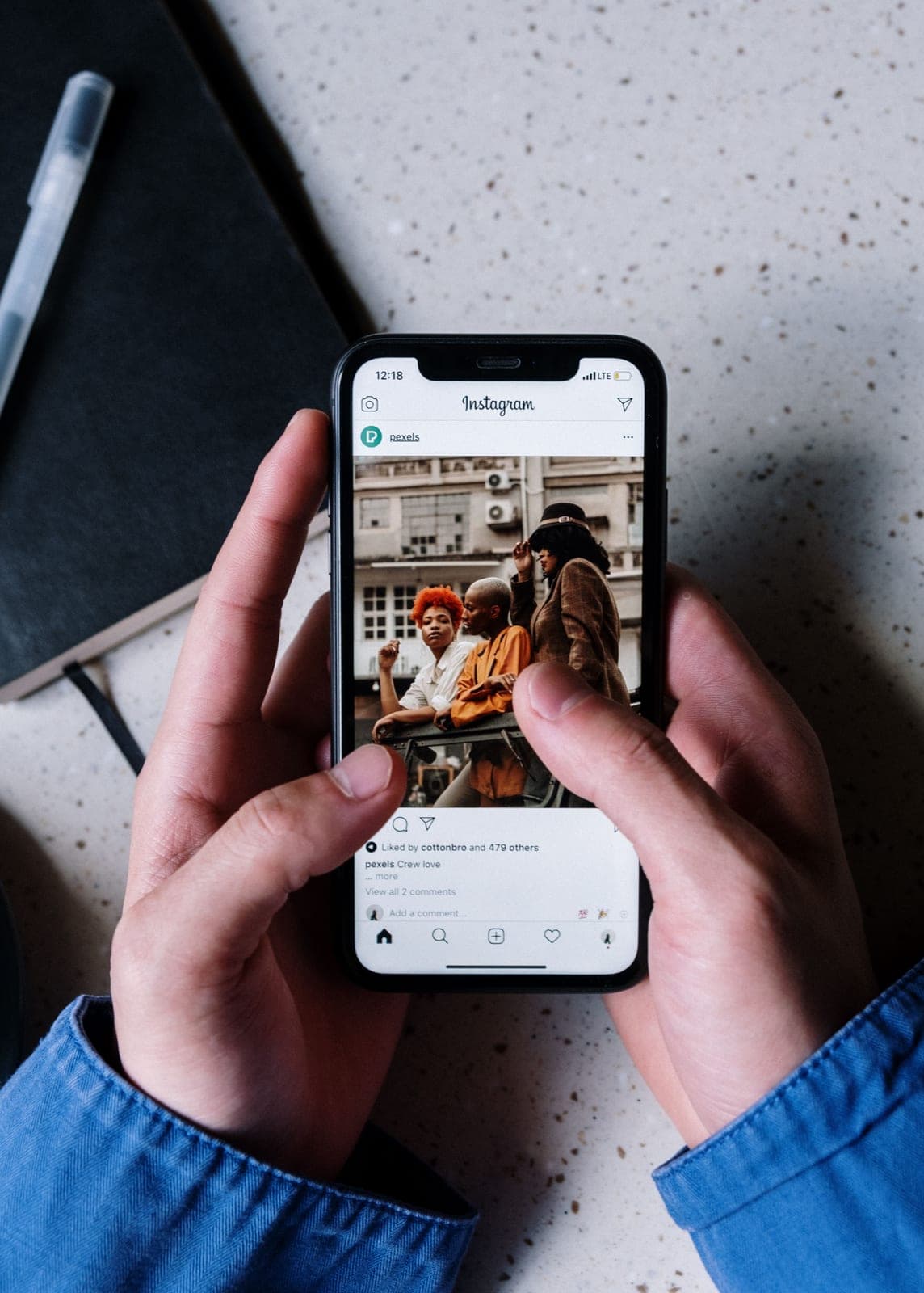 Hands holding a phone showing an Instagram post